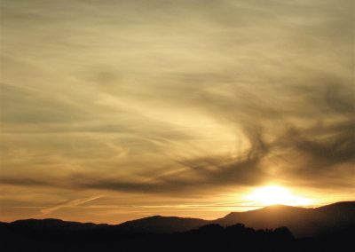 Sunset over mountains with golden clouds. Pauline Christie