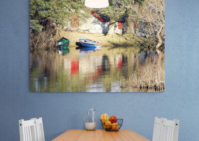 Boats on a lake reflecting a red building and trees; a beautiful nature landscape.