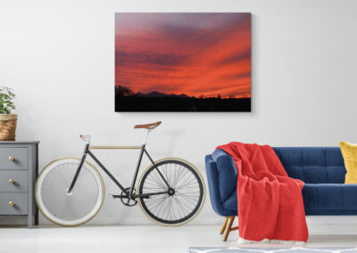 Modern apartment decor with a blue couch, bike, and sunset painting. #smallspacedesign