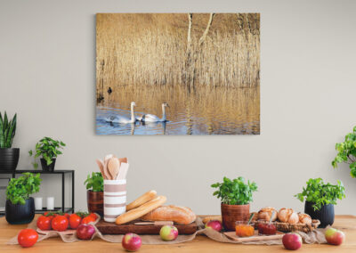 Breakfast table setting with bread, apples, and jam under a swan painting. Food photography