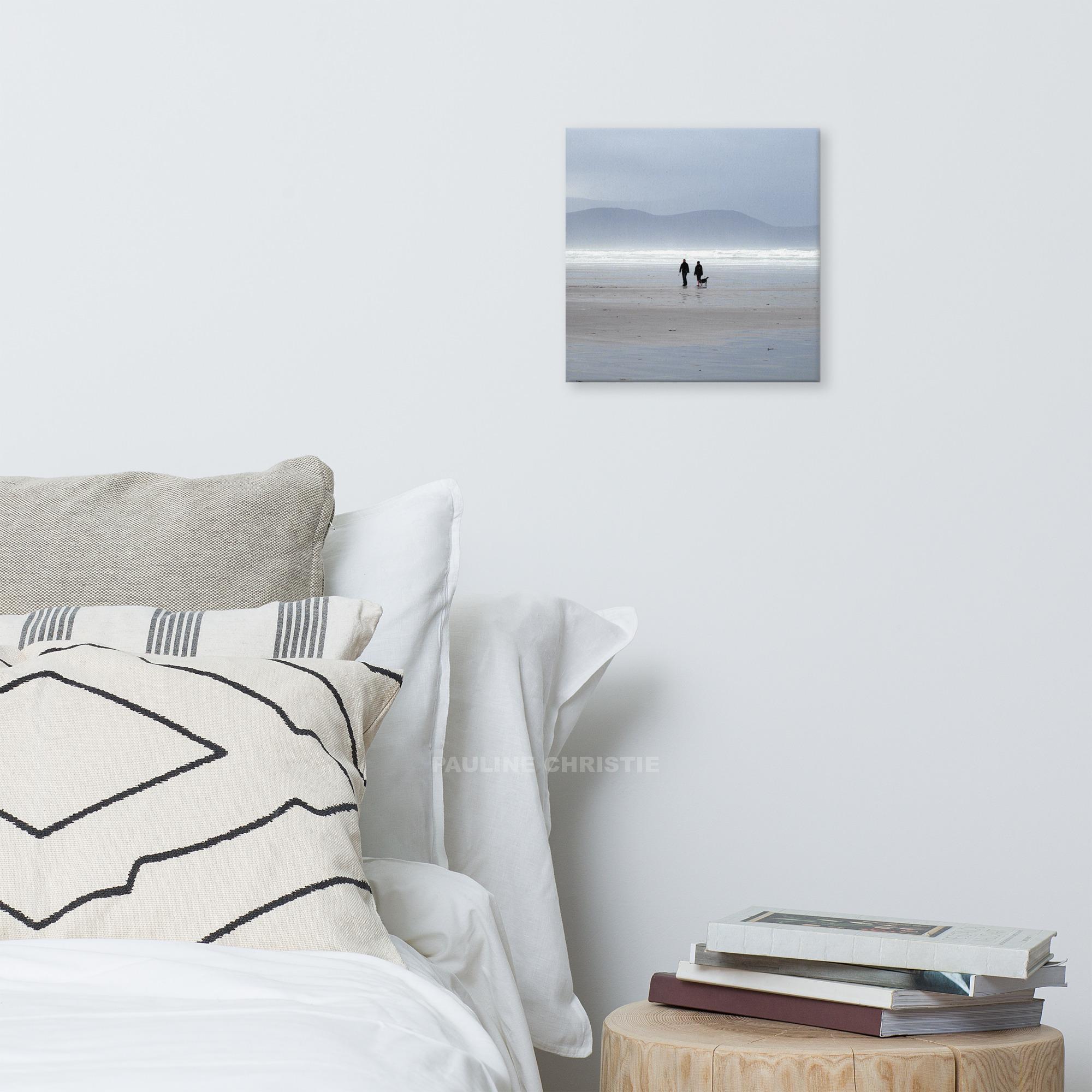 Couple walking their dog on Inch Strand beach in Kerry, Ireland.