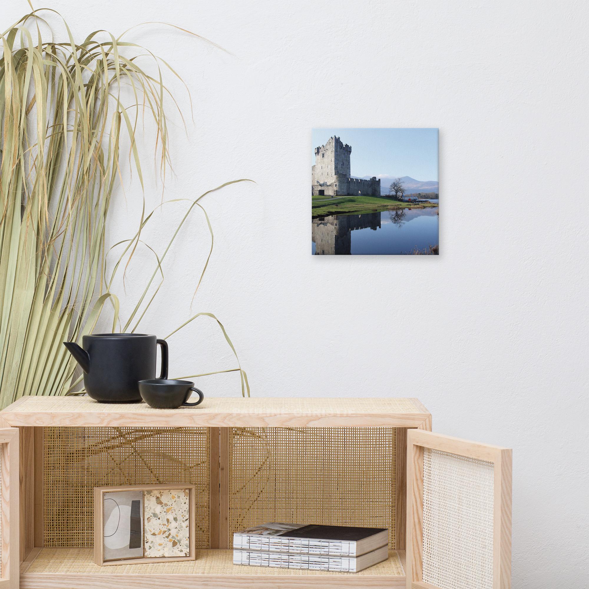 Ross Castle in Killarney, Ireland, reflected in the lake on a sunny day.