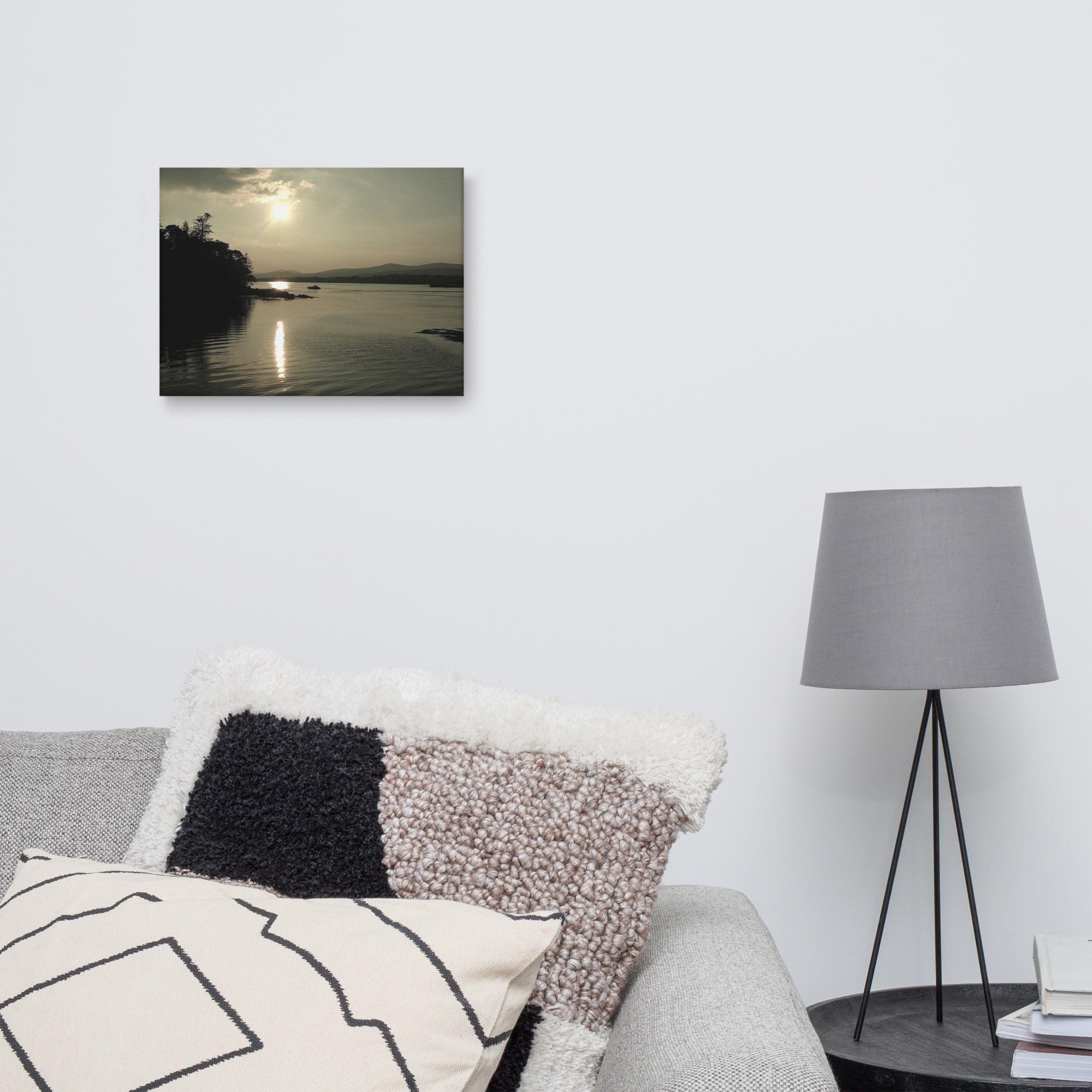 Sunset over Kenmare Bay reflected in the water. Framed landscape art above a couch.