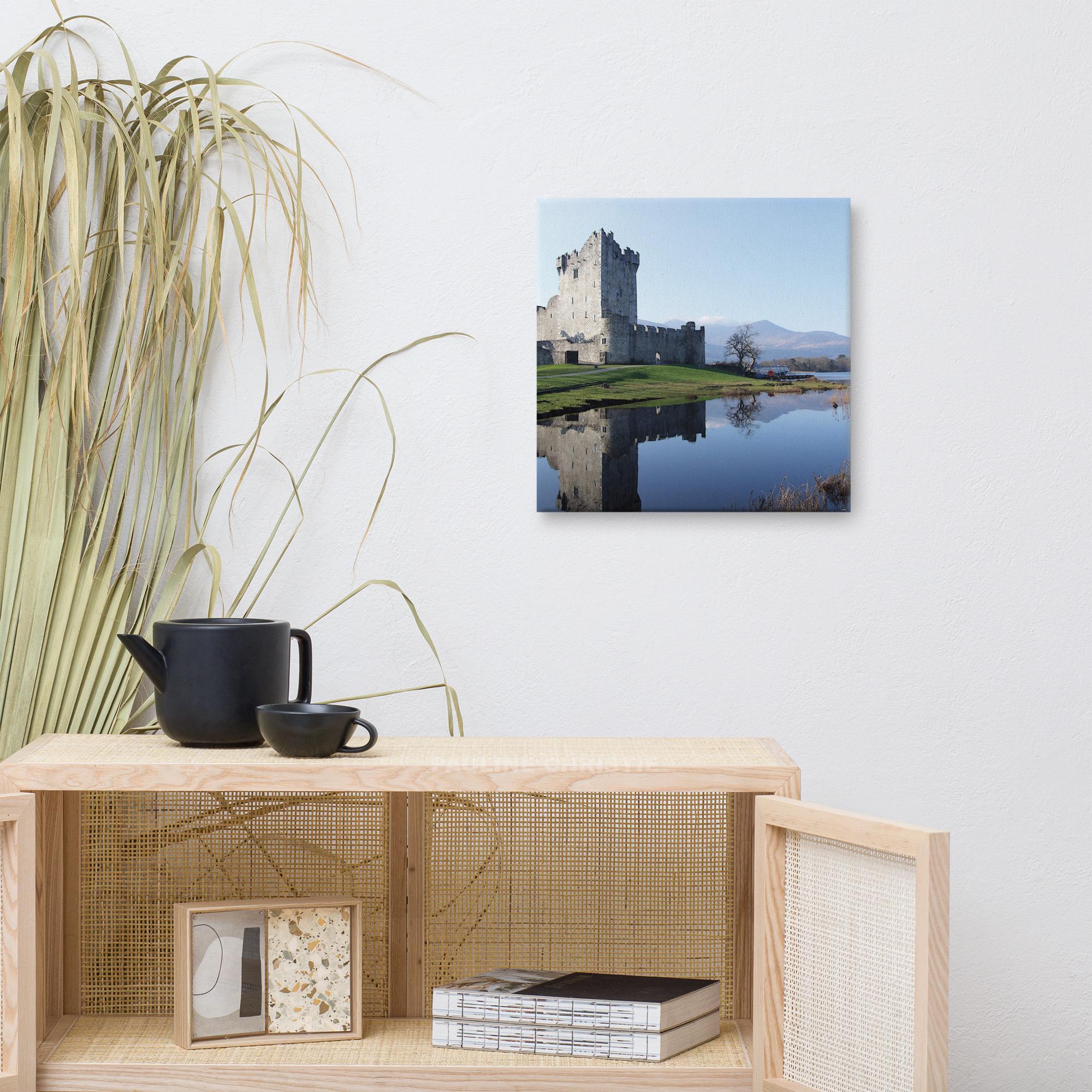 Ross Castle in Killarney, Ireland, reflected in the lake on a sunny day.