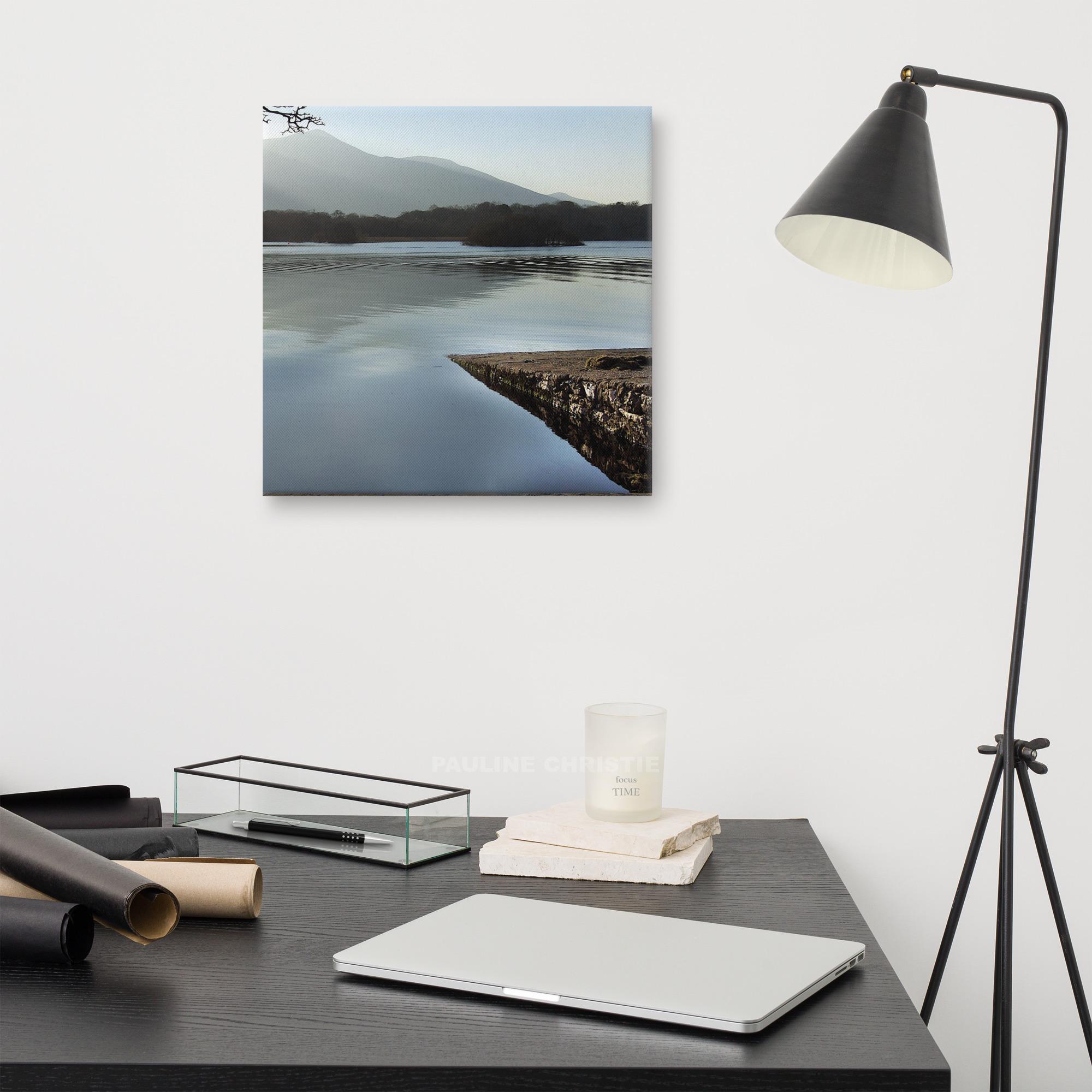 Peaceful lake scene in Killarney with mountain view and a rocky pier.