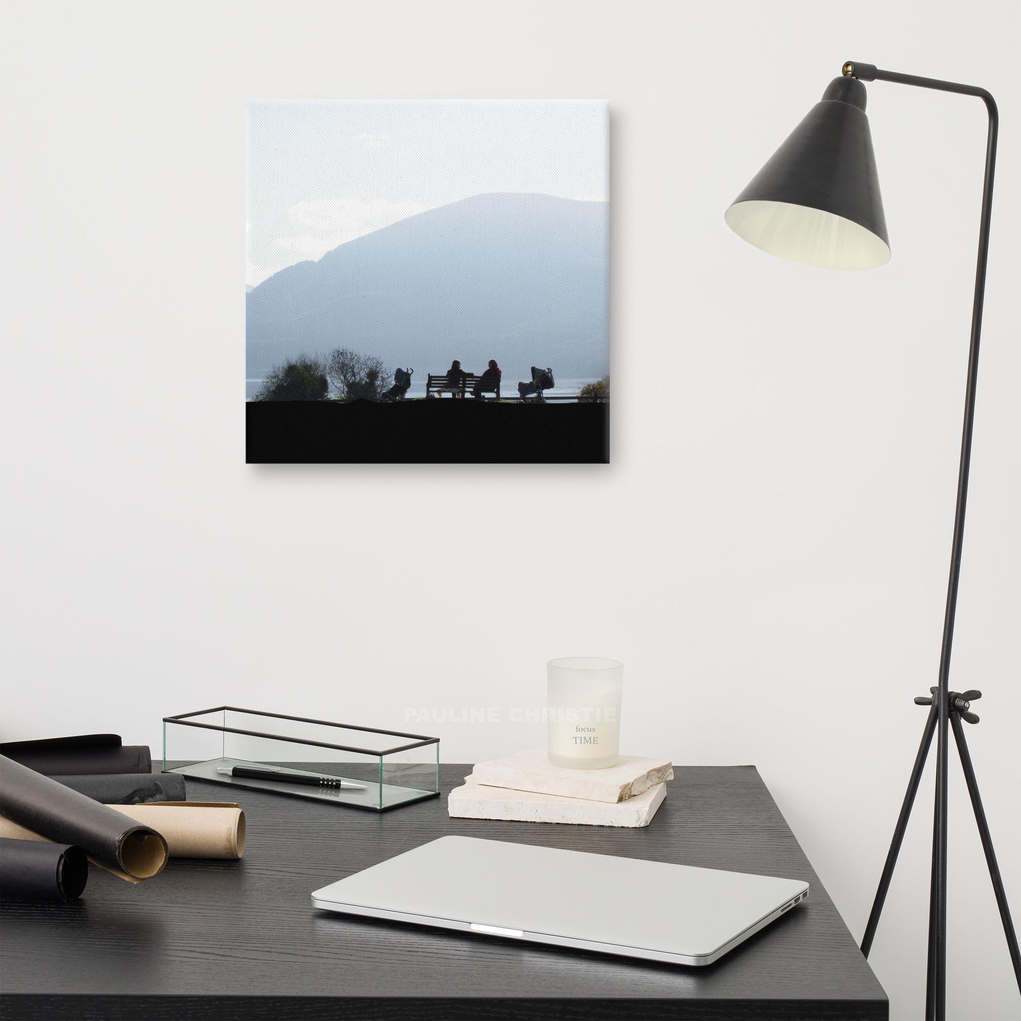Silhouettes of women chatting on a bench at Killarney Lakes, with mountains in the background.