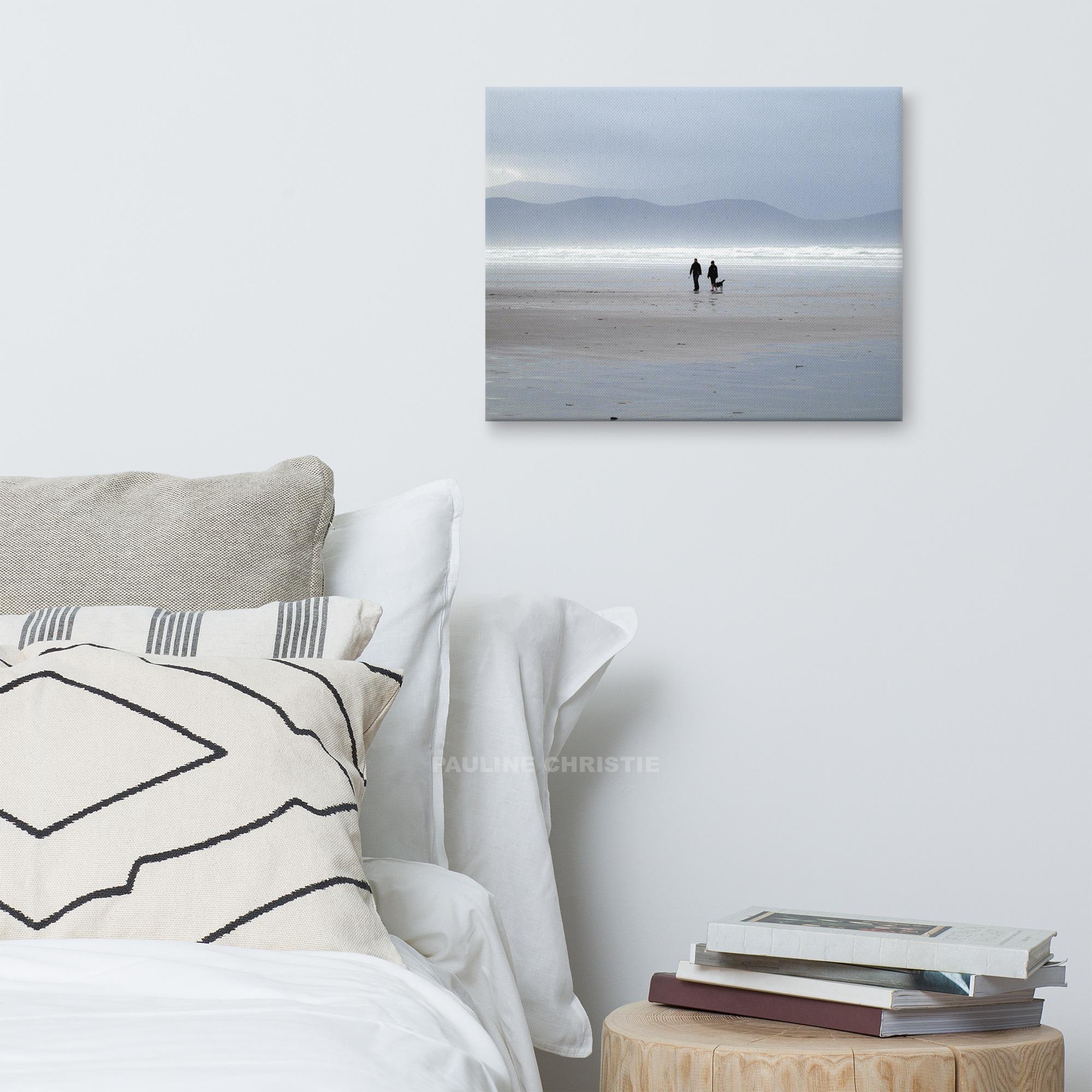 Couple walking their dog on Inch Strand beach in Kerry, Ireland.