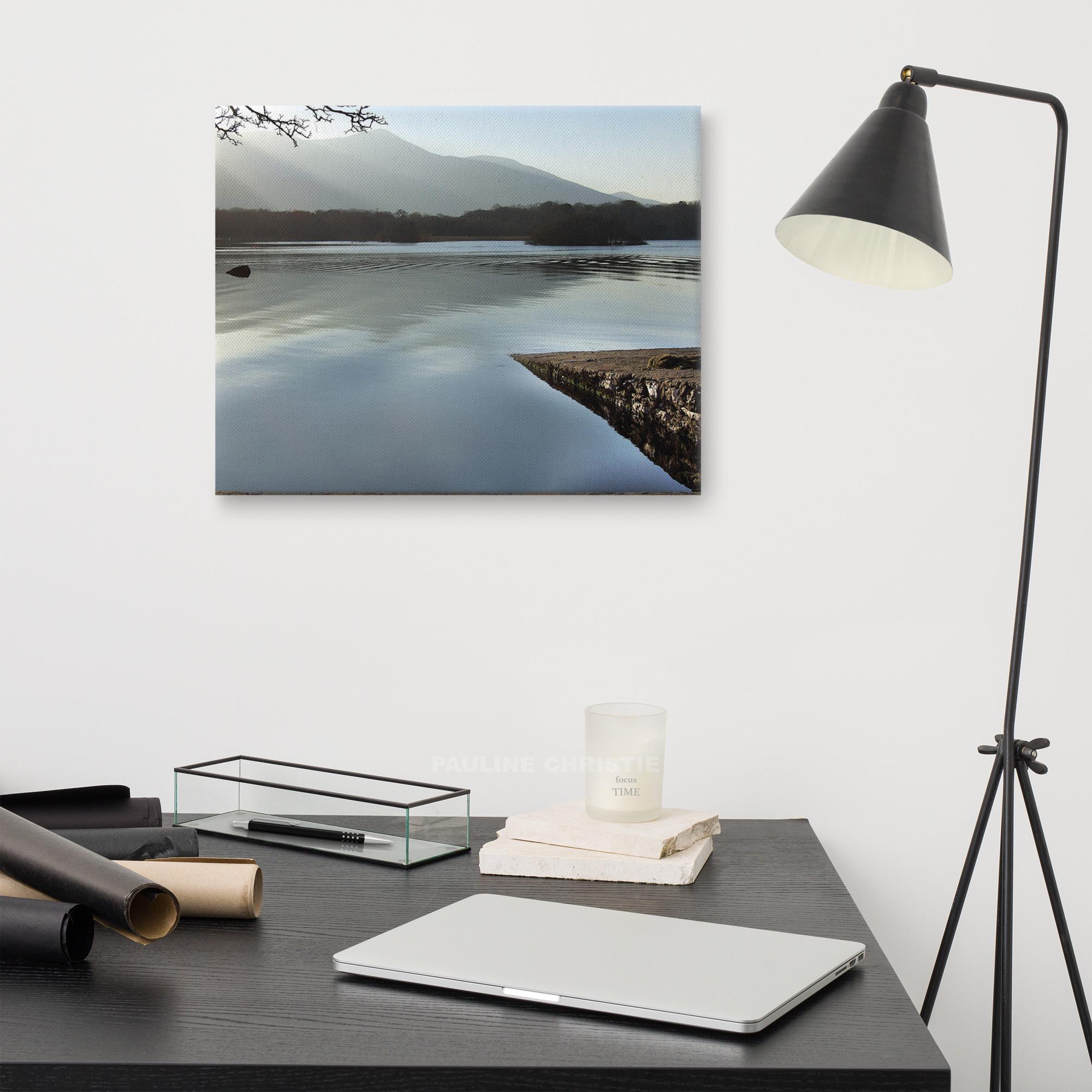 Peaceful lake scene in Killarney with mountain view and a rocky pier.
