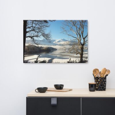 Magical winter lake scene with snow-covered mountains and frosted trees.