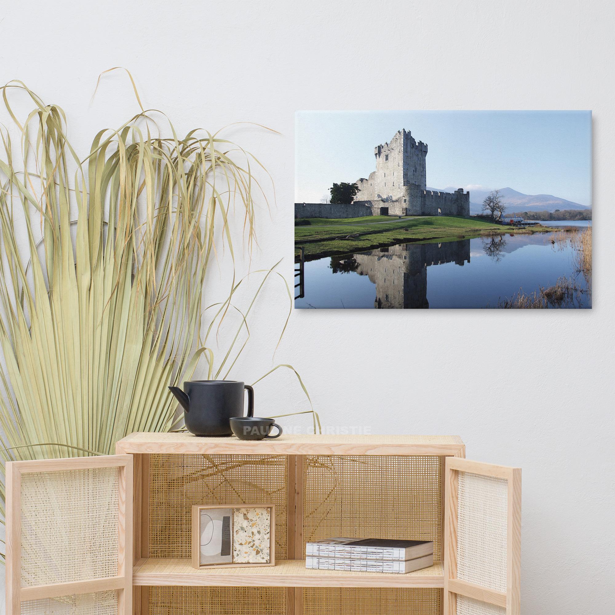 Ross Castle in Killarney, Ireland, reflected in the lake on a sunny day.