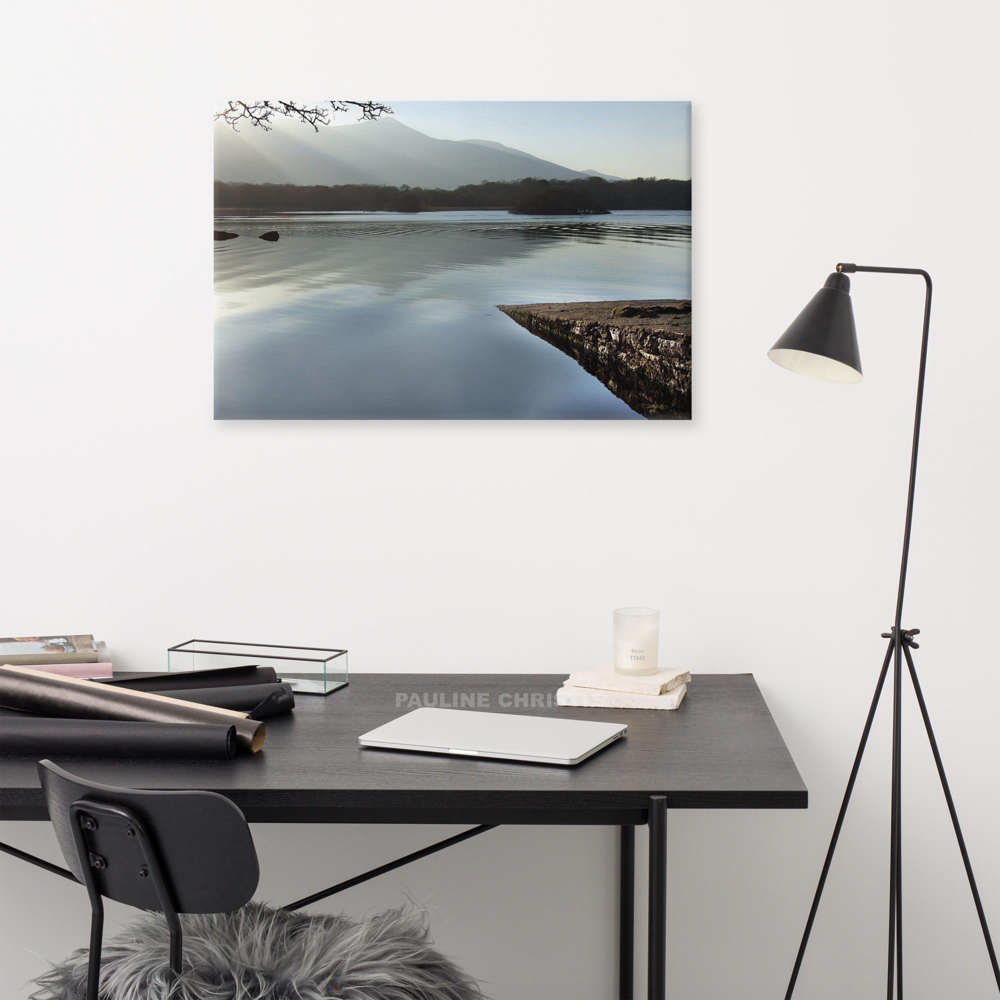 Peaceful lake scene in Killarney with mountain view and a rocky pier.